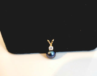 Pearl necklace with a gold clasp on a black stand