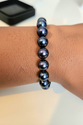 Black Freshwater bracelet on a wrist with a blurred background