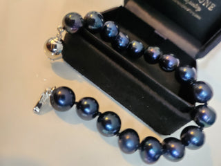 Black beaded bracelet on a black velvet stand with a blurred background