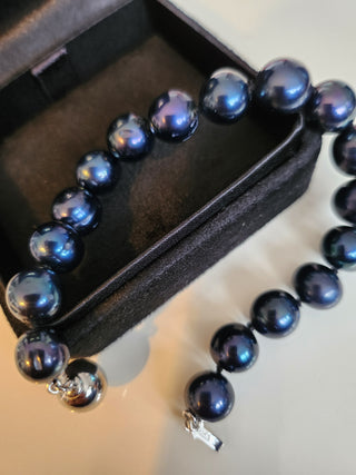 Black beaded bracelet with white gold clasp on a black box