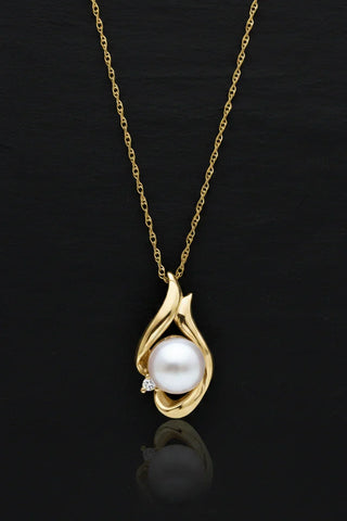 Elegant gold pendant necklace with lustrous pearl and diamond accent, perfect for timeless elegance