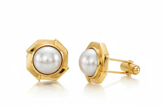 Gold cufflinks with pearl centres on a white background