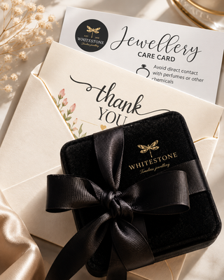 Black velvet jewelry box with a bow, Whitestone branded card, and envelope on a neutral background