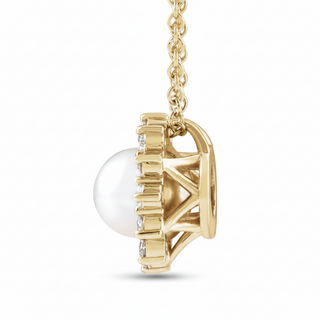 A gold pendant necklace featuring a large white pearl partially set within an openwork gold frame, with small clear stones along the side, shown on a white background.