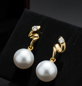 Gold earrings with pearls on a white background