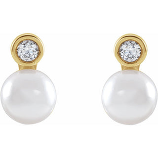 Pair of pearl earrings with gold and diamond accents on a white background