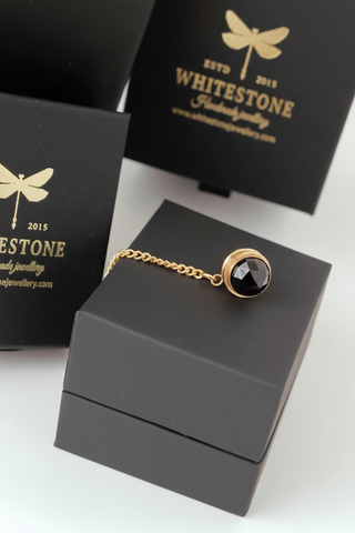 Gold and black jewelry piece on a Whitestone branded box with dragonfly logo.