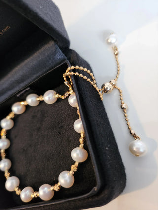 Pearl bracelet with gold chain on a black jewelry box