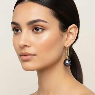Woman wearing a black pearl earring on a beige background