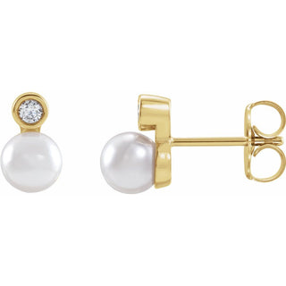 Gold earrings with pearls and a small diamond on a white background