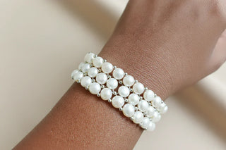 Hand wearing handcrafted pearl stretch bracelet with silver accents, Whitestone Jewellery