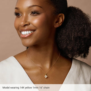 Woman wearing 14K yellow gold 1mm 16 inch chain necklace with pendant