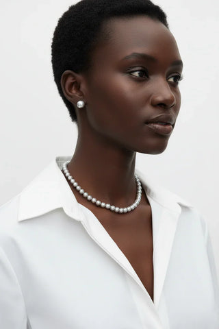 Black model with short hair wearing grey pearl necklace with matching stud earrings 