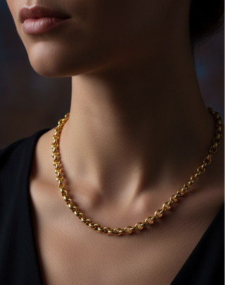 Gold chain necklace on a person against a dark background