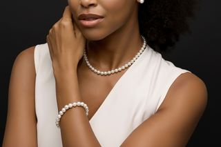 Woman wearing a pearl necklace and bracelet against a beige background