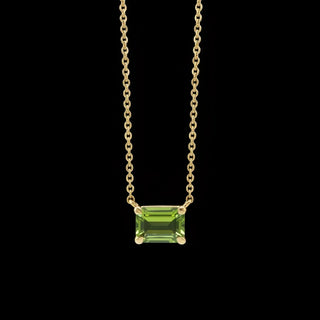 Emerald cut green gemstone pendant on a delicate gold chain necklace.