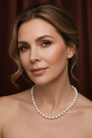 Elegant woman wearing a classic pearl necklace, showcasing timeless sophistication and refined beauty.