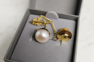 Pearl earring with gold chain in a gray box