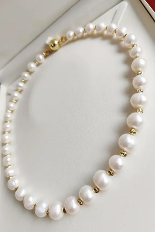 Handcrafted white pearl necklace with gold spacers in a white jewelry box
