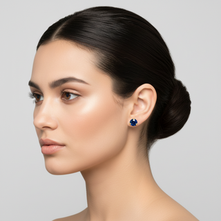 Woman wearing blue 3mm sapphire gemstone earrings with a neutral background