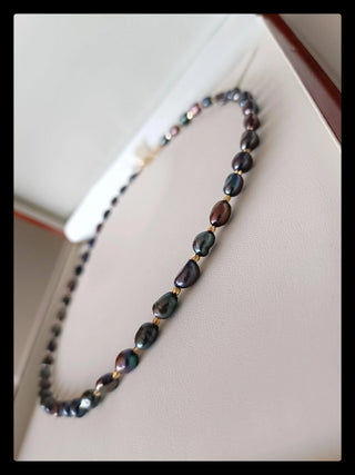 Handcrafted dark baroque pearl necklace on a white display box